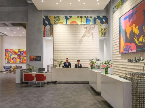 two men sitting at a reception desk in a lobby at Pullman Jakarta Central Park in Jakarta