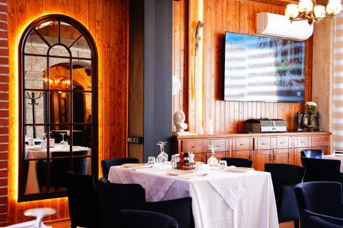 a dining room with tables and chairs and a mirror at Vila 15 By Nam Nam Tirane in Tirana