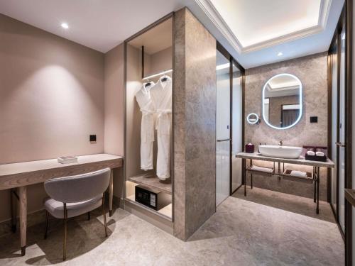 a bathroom with a sink and a mirror at Mercure Beijing Downtown in Beijing