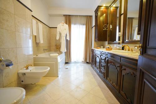 a bathroom with a sink and a toilet and a tub at Hotel Casa Capsa in Bucharest