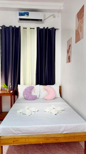 a bed with two pelicans pillows on it at Nowhere Siqujor Hostel in San Juan
