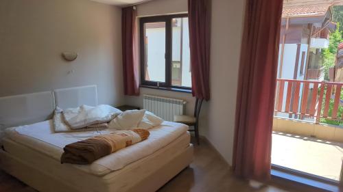 a living room with a couch and a window at Borovets Apartments, Flora Violet Residence in Borovets