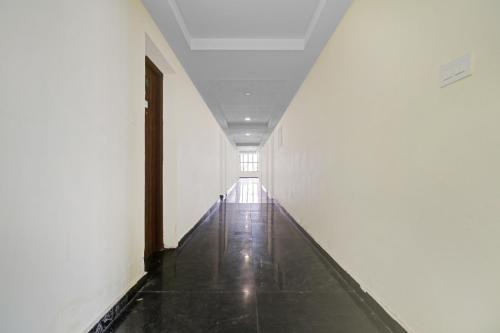 Un pasillo vacío con una puerta en un edificio blanco. en Hotel O NSK Residency, en Madurai