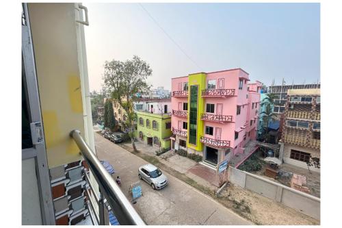 a view from a balcony of a pink building at Near Sea Beach HOTEL GANGA ARTI !NN ! Digha, Prime Location Near Jagannath Temple- Fully Air conditioned Rooms ,Wifi -Lift and Restaurant, Parking Facilities - A Top Rated Hotel IN DIGHA in Salt Lake City