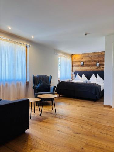 ein Hotelzimmer mit zwei Betten, einem Tisch und Stühlen in der Unterkunft Typically Swiss Hotel Ermitage in Kandersteg
