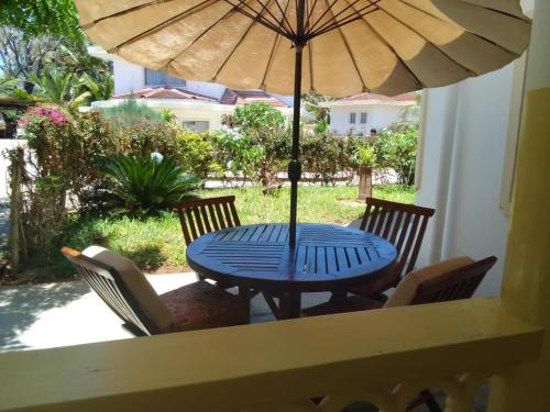 ワタムにあるSikuMoja Watamu 4 Bed HolidayHomeの青いテーブル(椅子、パラソル付)