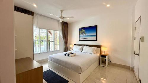 ein weißes Schlafzimmer mit einem Bett und einem Fenster in der Unterkunft Secret Valley near Phuket Town in Kathu