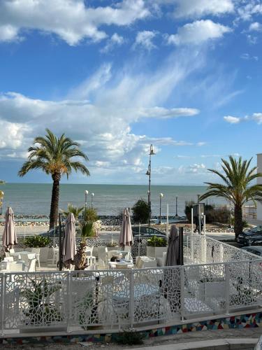 a table with chairs and umbrellas on the beach at La Maison di Bea in Manfredonia
