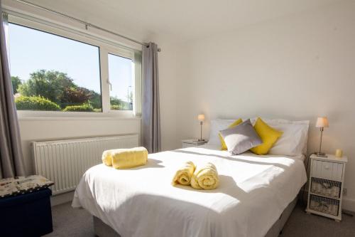 a bedroom with a large bed with towels on it at Lydgate, Benllech - Sleeping 6 in Benllech