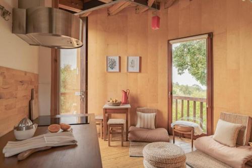 a living room with a table and chairs and a window at CABRA - Porto Covo in Porto Covo