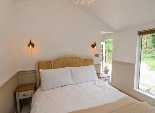 a bedroom with a white bed with a window at Alum House Littlebeck, Whitby - Roe Deer Lodge in Sleights