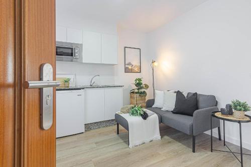 a living room with a couch and a kitchen at Terreo 10-12 in A Coruña