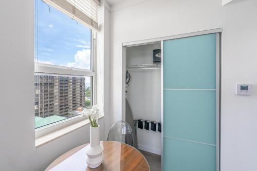 a bathroom with a glass shower and a table at Spacious Connecting Studios Sleeps 4 with 2 Parking Spots in Miami