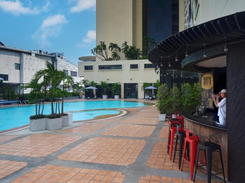 a swimming pool with red tables and chairs next to a building at Novotel Bangkok on Siam Square in Bangkok