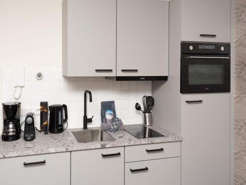 Una encimera de cocina con fregadero y microondas. en Luxury apartment in Renesse with infrared sauna, en Renesse