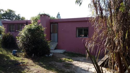 a pink house with a tree in front of it at Peckes in Balneario Buenos Aires