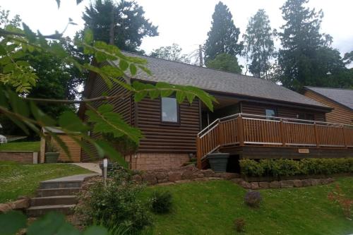 a log home with a deck and grass at 2 Bed Cottage Sleeps 4 -Private Garden -Pets Okay in Blairgowrie