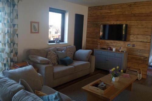 a living room with a couch and a tv at 2 Bed Cottage Sleeps 4 -Private Garden -Pets Okay in Blairgowrie