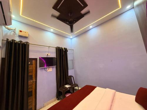 a bedroom with a bed and a ceiling fan at Vedas Suites- Saryu Ghat Ayodhya in Ayodhya