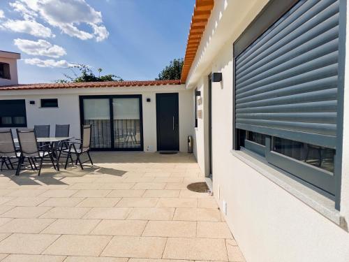 a patio with a table and chairs next to a building at Matias Nature - Mountain Lodges in Serra da Estrela, Seia in Carragozela