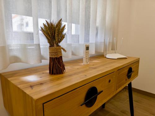a wooden table with a vase on top of it at Casas Matias Nature Serra da Estrela - Alojamentos em Seia in Carragozela