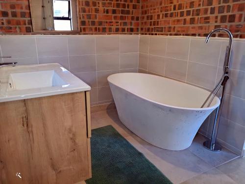a bath tub and a sink in a bathroom at The Loft in Gansbaai