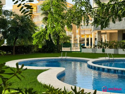a swimming pool in front of a building at El Apartamento in Benicàssim