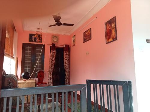 una sala de estar con paredes rosas y una cuna en Ashabhavan, en Varkala