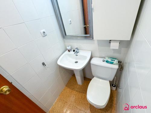 a small bathroom with a toilet and a sink at El Apartamento in Benicàssim