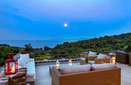 a patio with furniture and a view of the ocean at Villa Laurette Kratigos - Private Escape with Views in Pligónion