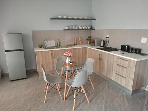 a kitchen with a table and chairs and a refrigerator at Melz & Sno Apartments in Mbabane