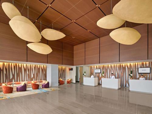 a lobby with couches and tables and large lights at Novotel Saigon Centre in Ho Chi Minh City