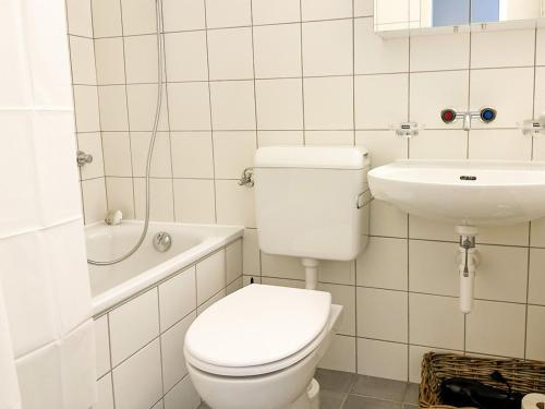 a white bathroom with a toilet and a sink at Vully Panorama Apartment 3 Schlafzimmer nahe Bern in Zollikofen