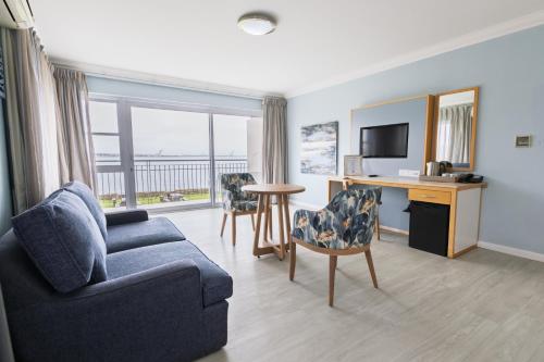 Una sala de estar con un sofá y un escritorio. en Saldanha Bay Hotel, en Saldanha