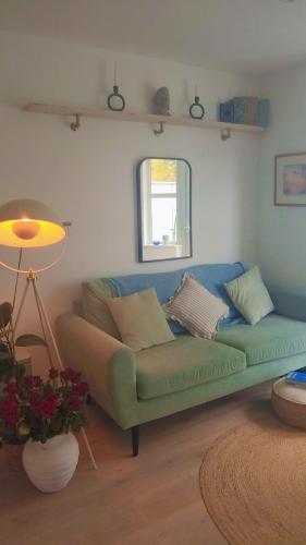 a living room with a green couch and a window at Beautiful flat in the heart of South London in London