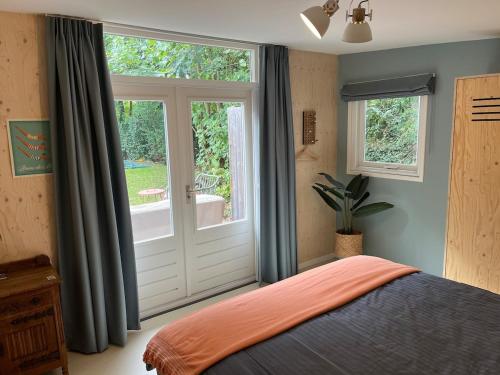 a bedroom with a bed and a sliding glass door at Fraaie familiebungalow op heerlijk rustige plek in Ouddorp