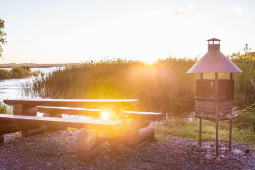 a picnic table and a bird house next to a lake at Ermistu Puhkeküla in Ermistu