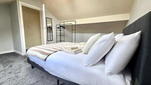 a bedroom with a white bed with white pillows at Comfy Entire Apartment with Free Parking in Bury Town in Bury