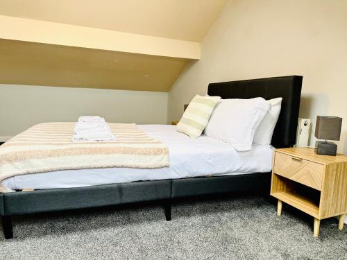 a bedroom with a large bed with white sheets and pillows at Comfy Entire Apartment with Free Parking in Bury Town in Bury