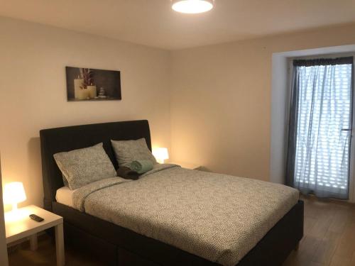 a bedroom with a bed and a window at Casa Maripaula Caminheiros in Belinho