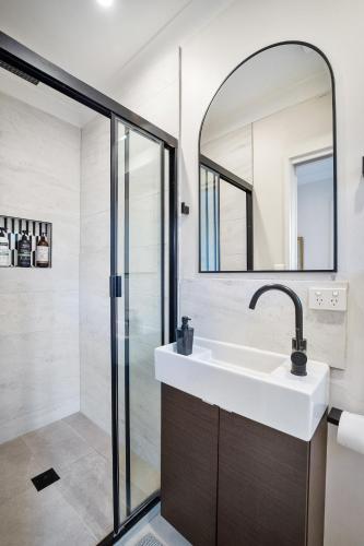 a bathroom with a sink and a mirror at Luxury Retreat Home - 4bed House w/Parking - Mins from CBD in Sydney