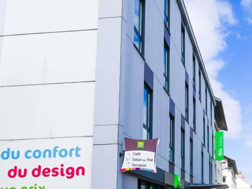 Un edificio con un cartel al costado. en ibis Styles Montbéliard, en Montbéliard
