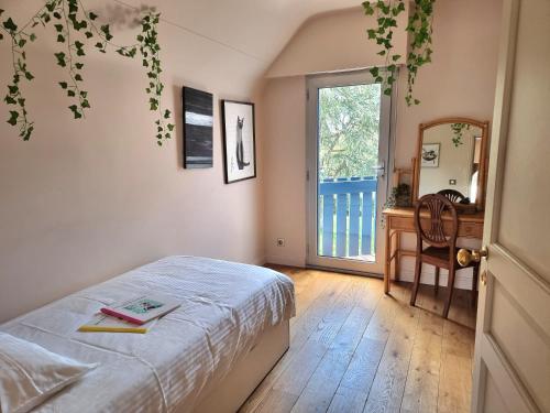 a bedroom with a bed and a desk and a window at La villa M Vannes, villa les pieds dans l'eau sur le port, avec grand jacuzzi in Vannes