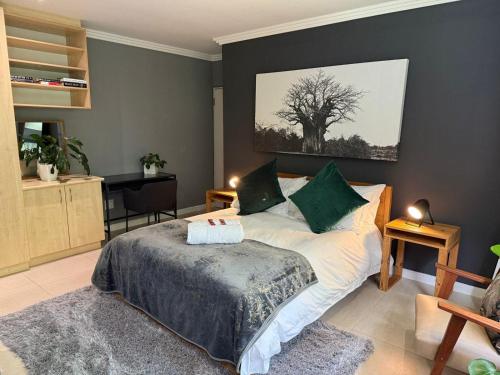 a bedroom with a bed with a tree on the wall at 14 Wylant Street in Welgemoed