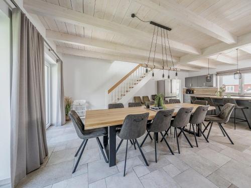 une cuisine et une salle à manger avec une table et des chaises dans l'établissement Nordseehaus für Gruppen - hell, modern, komfortabel, à Dagebüll