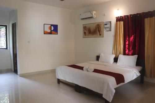 une chambre avec un grand lit dans une pièce dans l'établissement St. Anthony guest house., à Anjuna