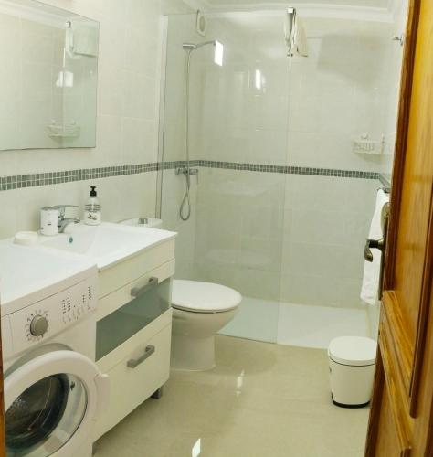 a bathroom with a toilet sink and a washing machine at Aguycan - Bungalow with ocean views in San Bartolomé