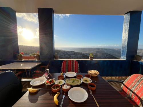a table with plates of food on it with a view at Al-Bustan House& Umm Qais in Um Qeis