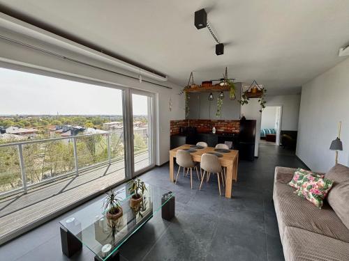 a living room with a table and a large window at Apartament Corner Śrem in Śrem