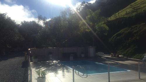 a swimming pool with the sun shining over it at Sítio Vitória in Barracão